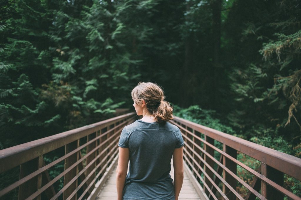 Girl walking across a bridge