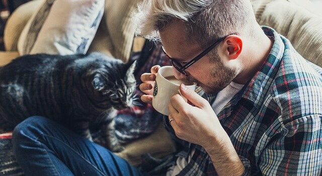 man with cat on sofa