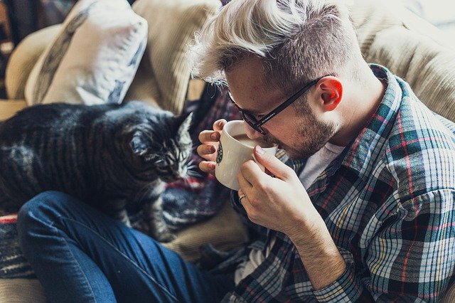 man with cat on sofa